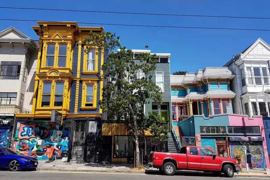 Vista di edifici colorati su Haight Street con auto parcheggiate lungo la strada. San Francisco, California.